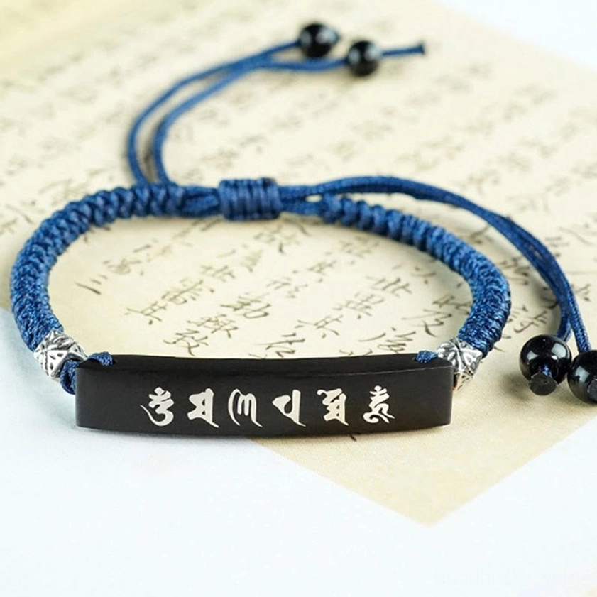 Handcrafted ebony wood protection bracelet with Six True Words mantra displayed flat on ancient Chinese calligraphy paper, showing horizontal white mantras on silver-inlaid tag