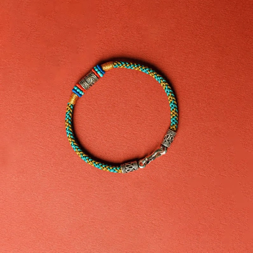 Full overhead view of Om Mani Padme Hum Buddhist bracelet with colorful threads and silver clasp