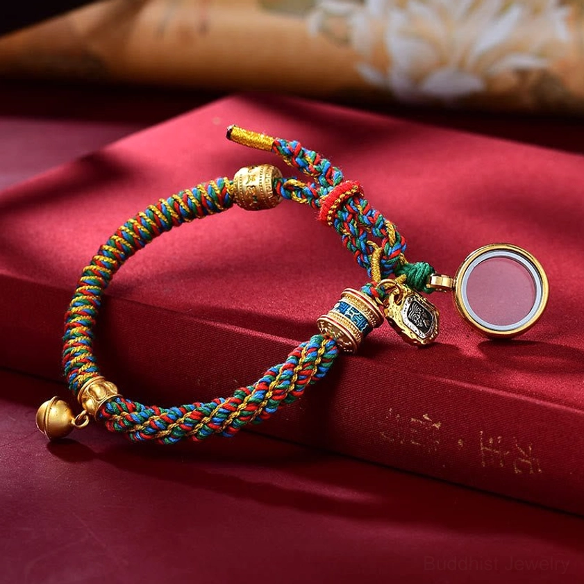 Single multicolored Buddhist string bracelet with round Ghau prayer box locket pendant and engraved mantra detail