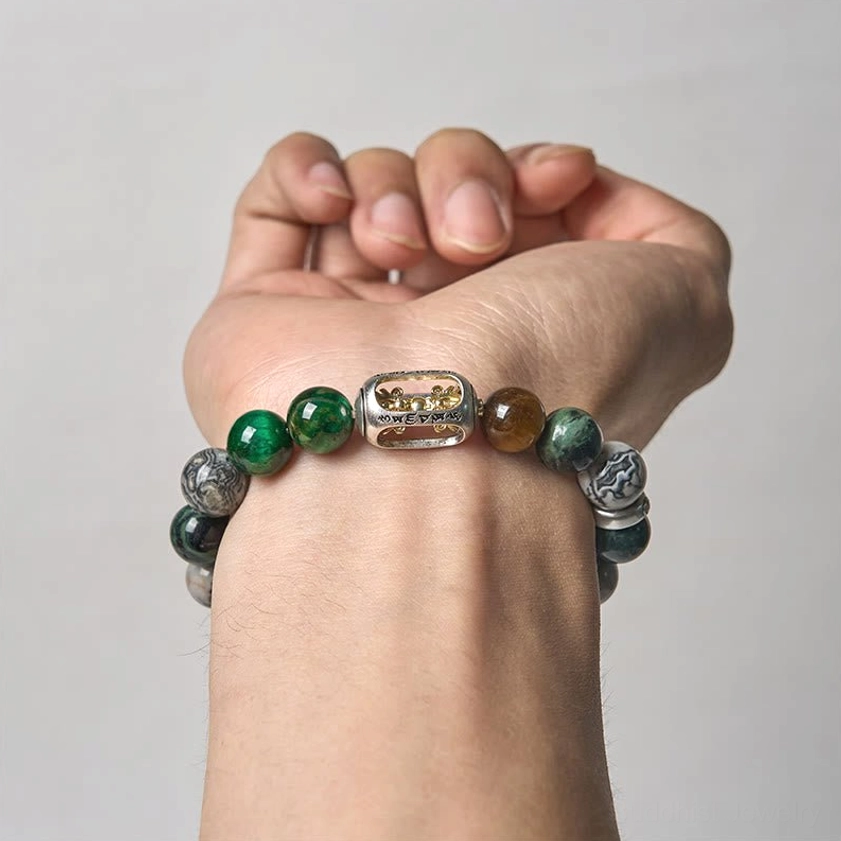 Buddhist protection bracelet worn on hand showing complete design with natural gemstone beads and metal center piece charm