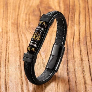 Om Mani Padme Hum leather bracelet with black titanium steel clasp and engraved mantra beads, shot from overhead perspective on wooden background