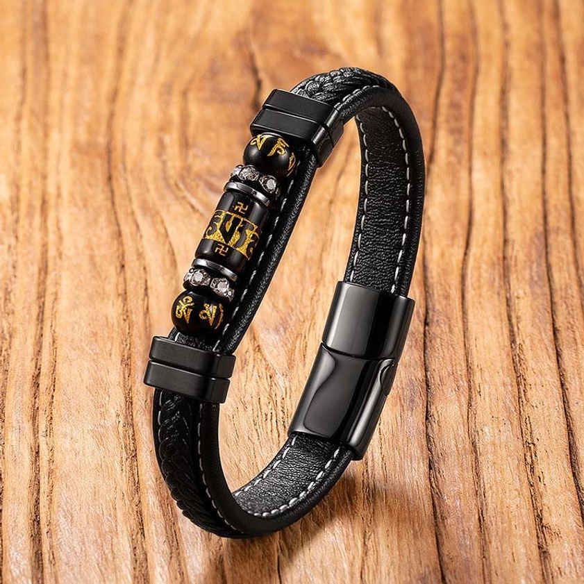 Om Mani Padme Hum leather bracelet with black titanium steel clasp and engraved mantra beads, shot from overhead perspective on wooden background