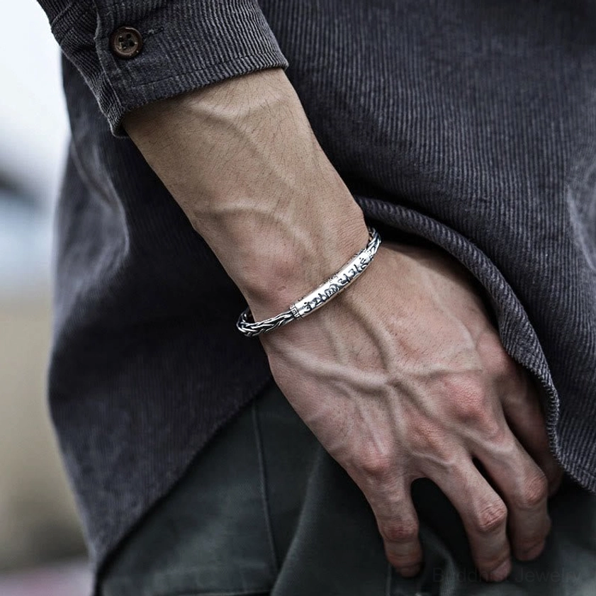 Buddhist mantra cuff bracelet paired with dark denim jacket in daily wear styling