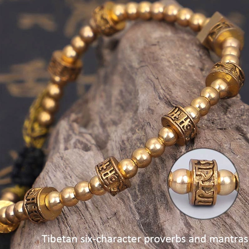 Tibetan Six-character mantra bracelet on wooden rock background with bronze beads and beige accents