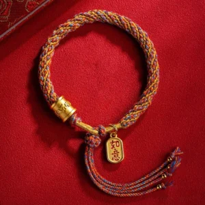 Handmade Om Mani Padme Hum multicolor braided bracelet with Ruyi charm on red velvet, flat lay top view