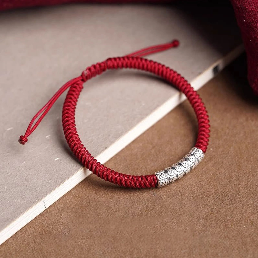 Sterling silver Om Mani Padme Hum bracelet with neat braided red cord and centered engraved charm