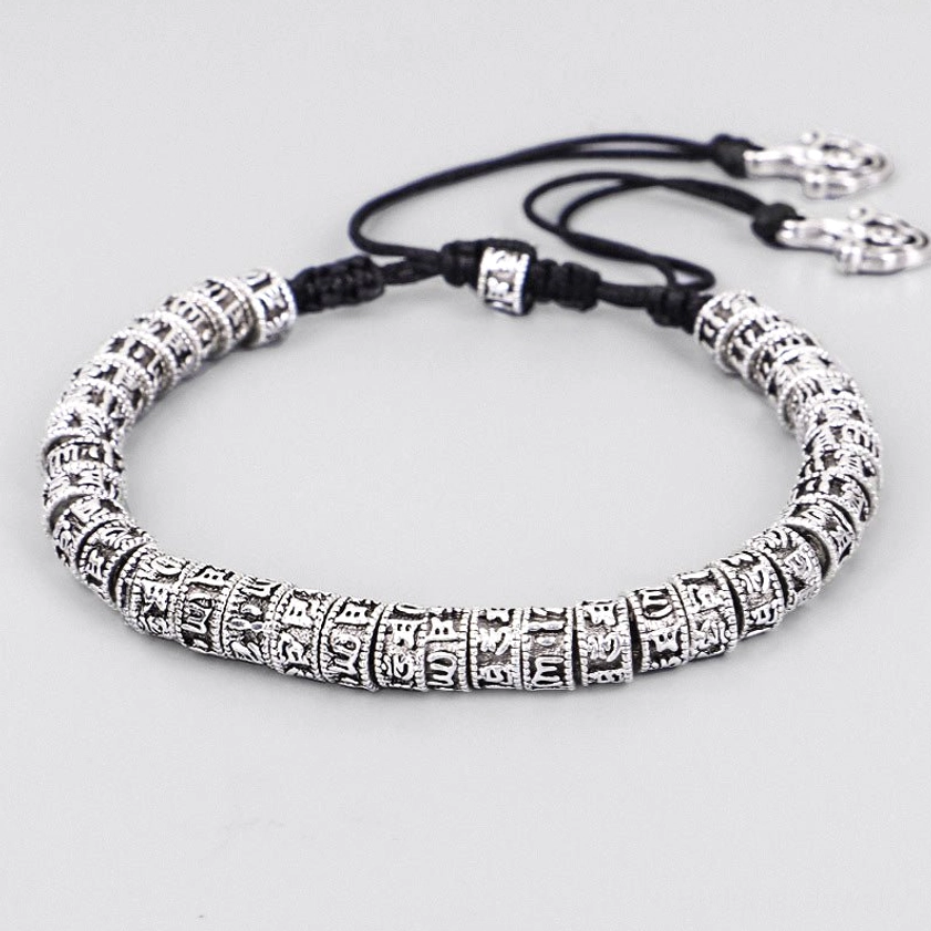Handmade Om Mani Padme Hum mantra bracelet with engraved silver alloy beads and black cord, side oblique view