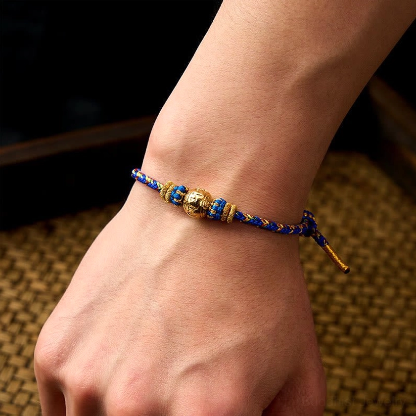 Wearing demo of handmade Buddhist string bracelet on wrist showing tri-color woven design and fit