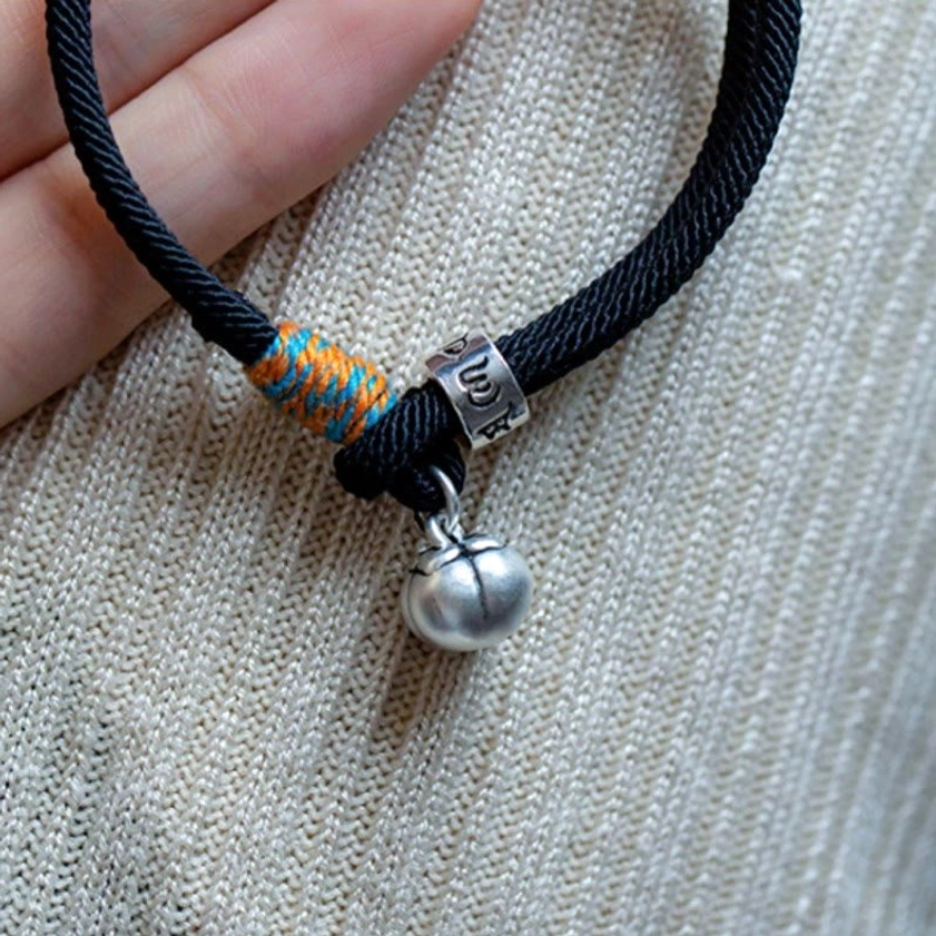 Om Mani Padme Hum bracelet worn on finger with knit fabric background showing mantra bead and charm details