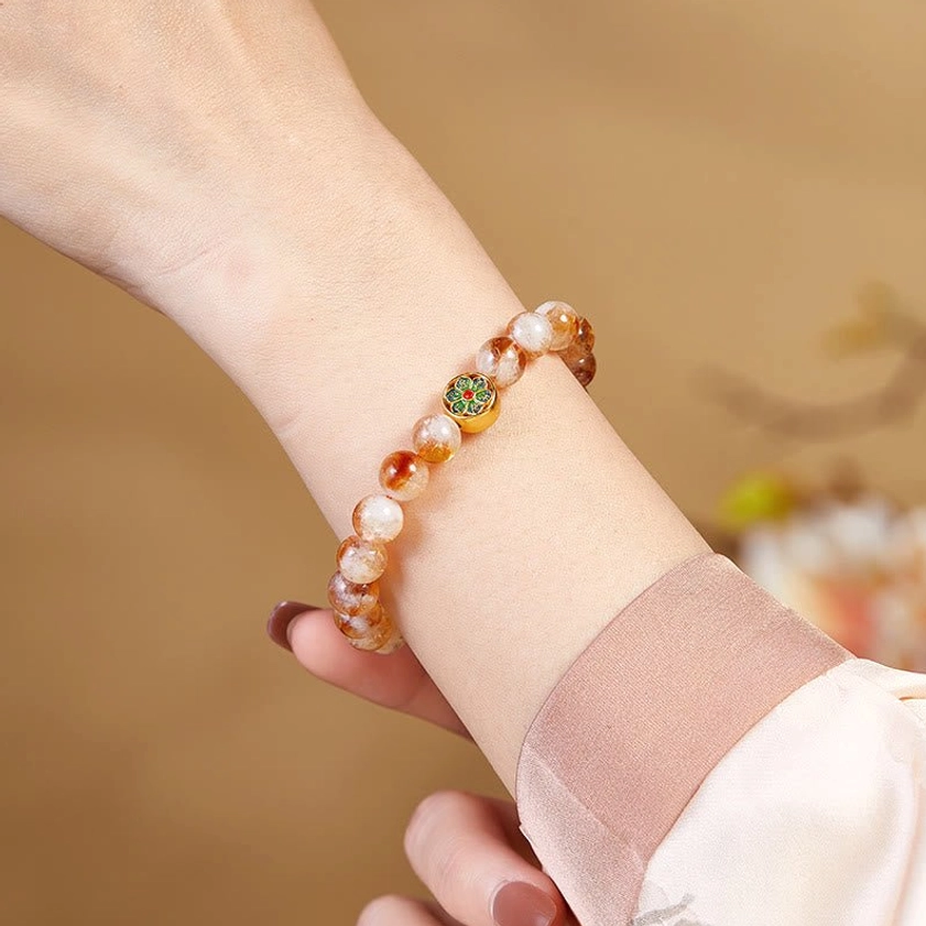 Citrine beaded Buddhist bracelet with sacred mantra charm worn on wrist lifestyle photography