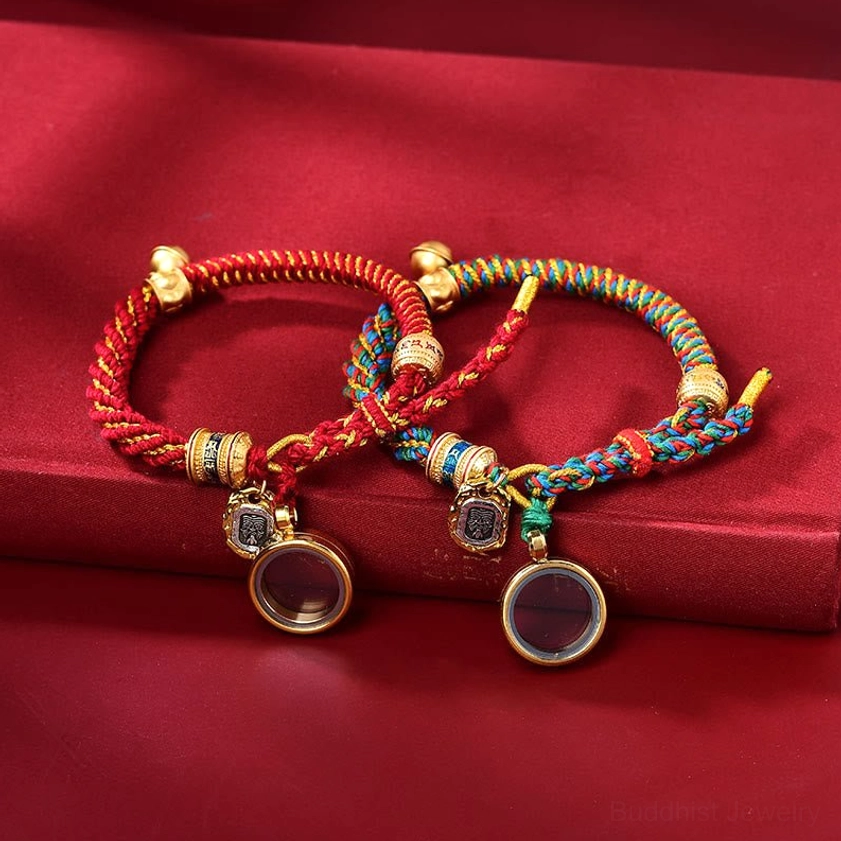 Two Buddhist string bracelets with mixed braided patterns displaying round locket pendants and metal charm bells