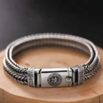 Om Mani Padme Hum braided copper bracelet with Six True Words buckle closure, overhead view showing twisted weave and ornamental details
