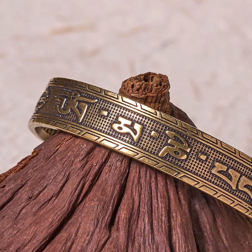 Side profile of sacred mantra brass bangle showing clear embossed Tibetan script and six-syllable Om Mani Padme Hum engraving