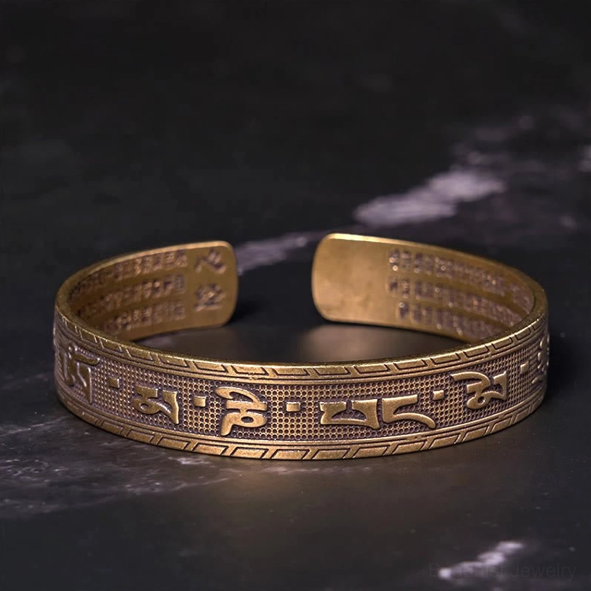 Top-down overhead view of sacred mantra open cuff bangle showing full engraved Om Mani Padme Hum text on outer surface with brass finish
