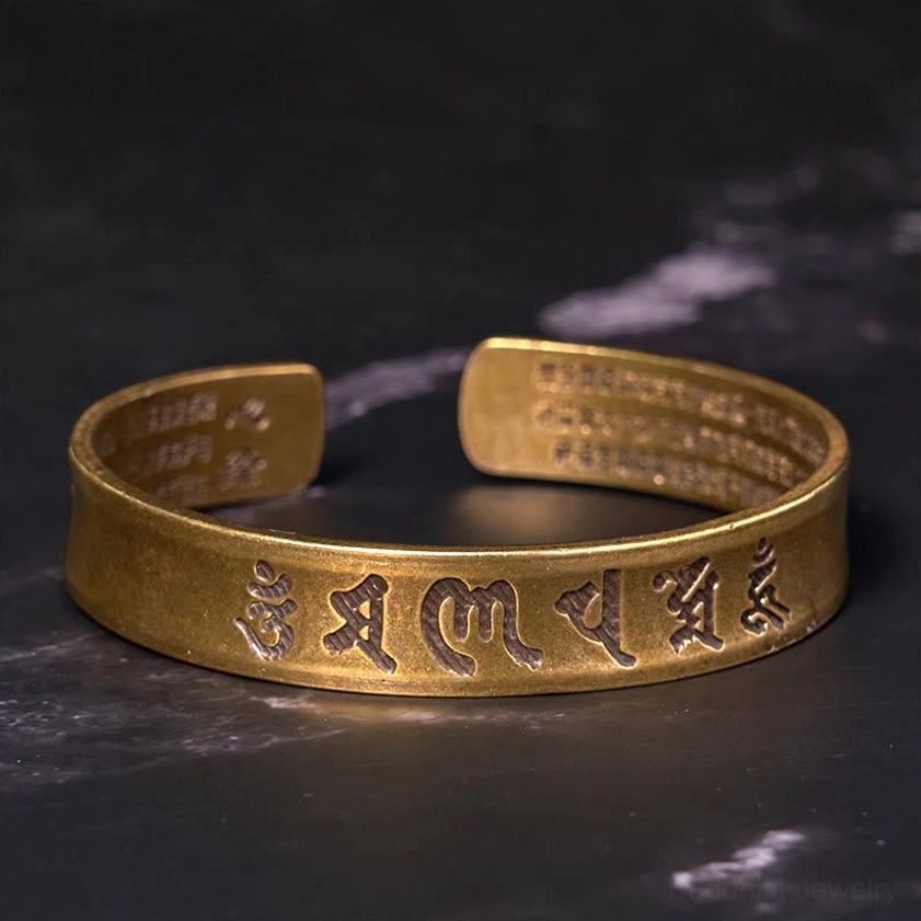 Om Mani Padme Hum mantra engraved on brass Buddhist cuff bracelet front view showing Sanskrit text