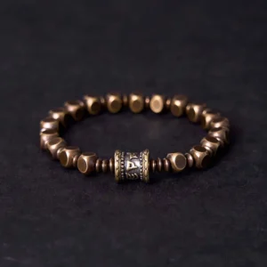 Om Mani Padme Hum brass mantra bracelet front view with carved center bead and faceted metal spacer beads