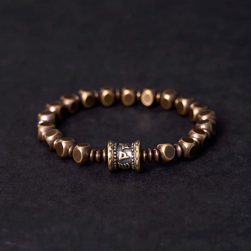 Om Mani Padme Hum brass mantra bracelet front view with carved center bead and faceted metal spacer beads