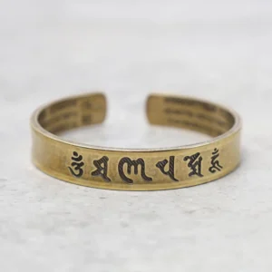 Om Mani Padme Hum brass mantra bracelet with hand-engraved Sanskrit script, polished gold tone open cuff design