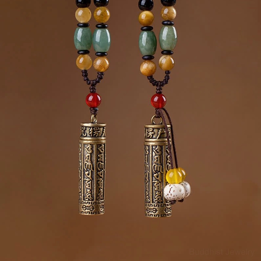 Buddhist protection necklace displayed on wooden surface with braided cord and engraved mantra pendant