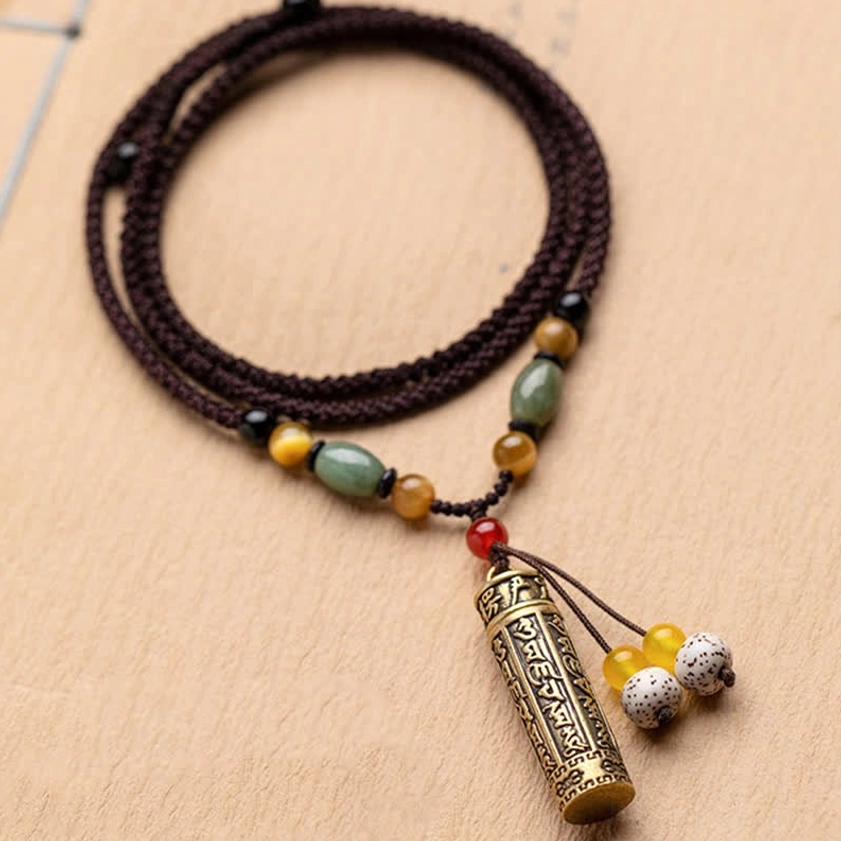 Buddhist mantra protection necklace with engraved bronze cylinder pendant and bodhi seed tassel details