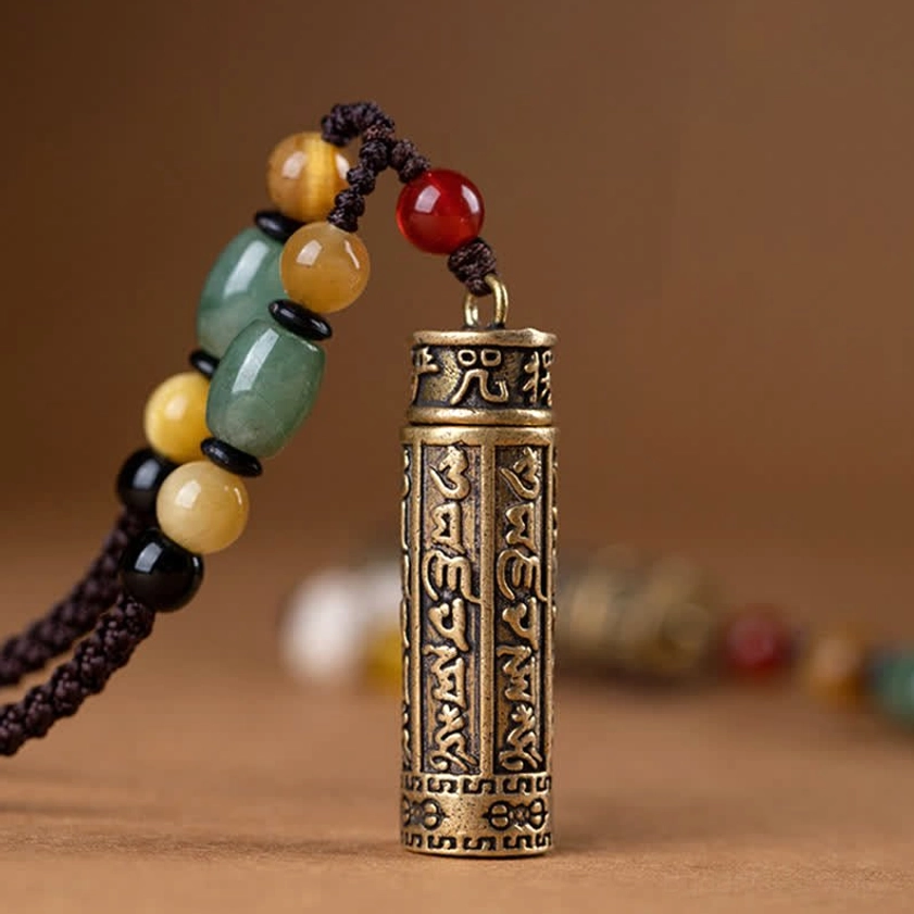 Close-up of Om Mani Padme Hum engraved bronze pendant showing detailed mantra carving and craftsmanship