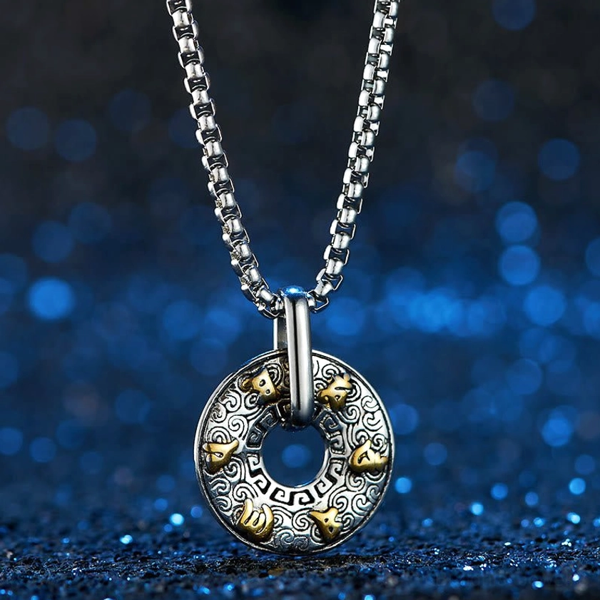 Gold-accented Om Mani Padme Hum Buddhist pendant necklace front close-up with full Sanskrit mantra symbols visible, photographed against blue bokeh starry background
