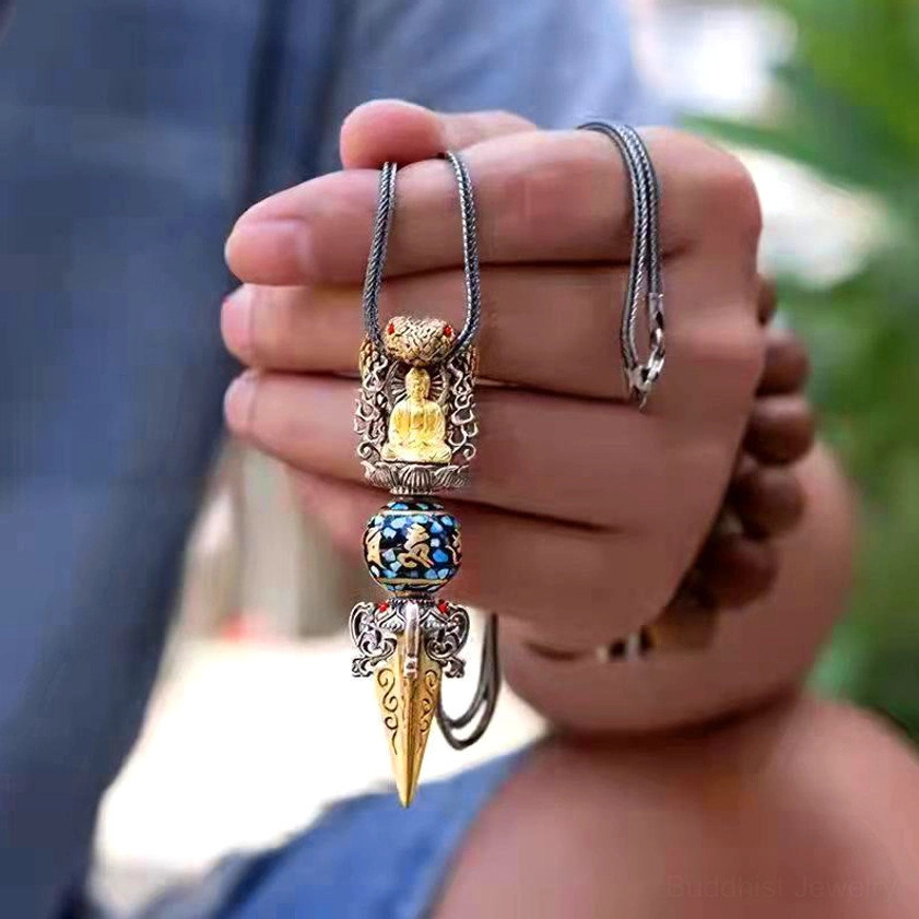Handmade Om Mani Padme Hum Buddhist necklace close-up - dual-tone metal Vajra with silver chain held in hand