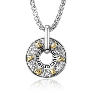 Om Mani Padme Hum Buddhist pendant necklace with silver and gold two-tone finish, close-up overhead view showing intricate mantra engraving and cloud pattern details on white reflective background