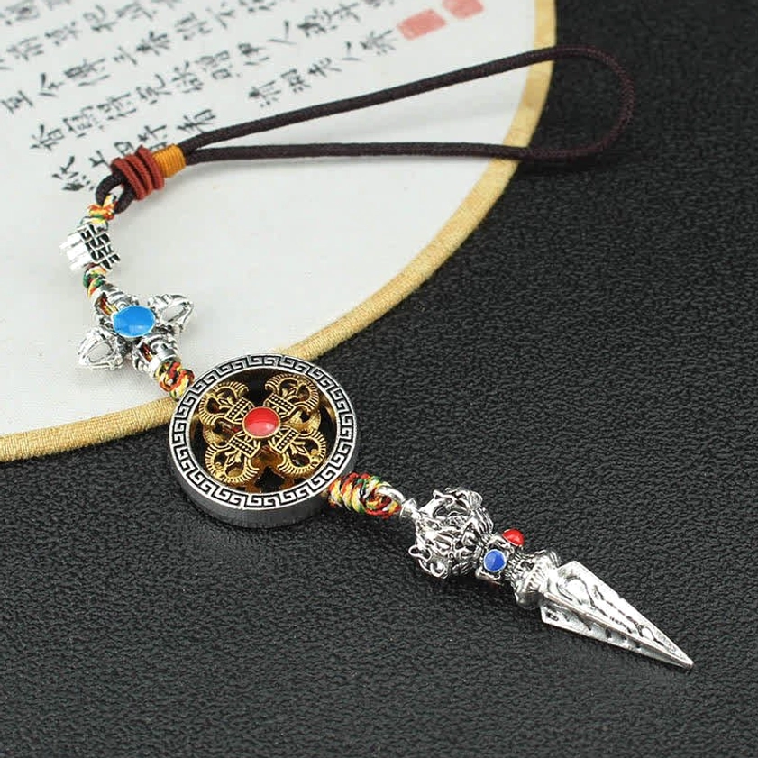 Top-down view of Buddhist car ornament with dharma wheel pendant and Vajra symbol inlaid with blue stones