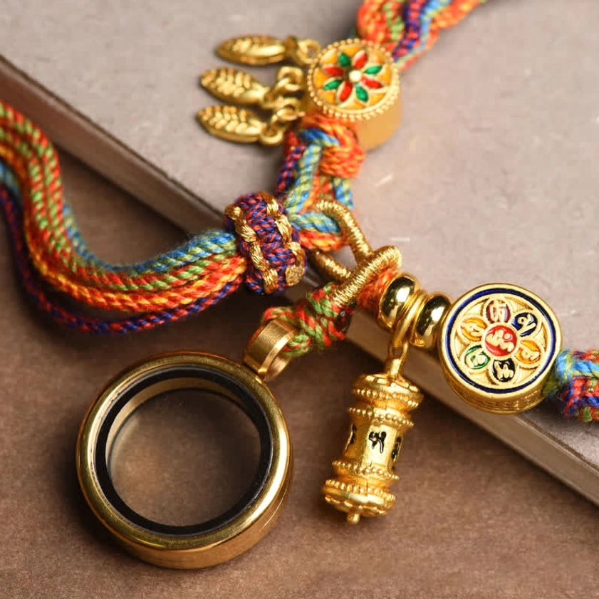 Buddhist prayer wheel enamel charm and round enamel emblem on colorful braided string bracelet