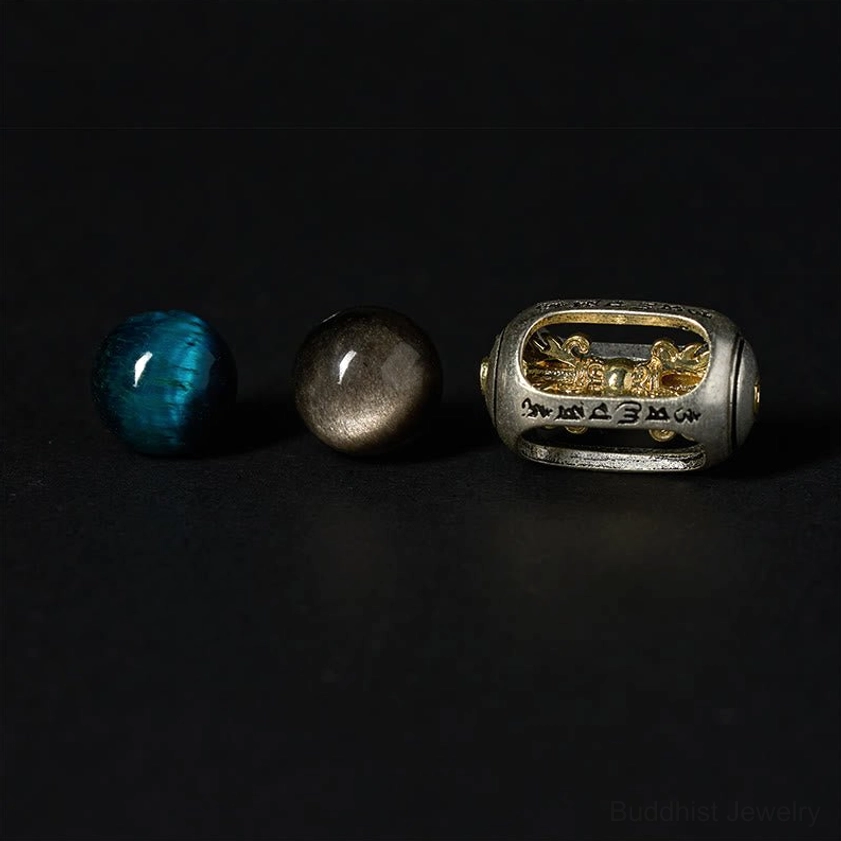 Single engraved Om Mani Padme Hum metal charm with Blue Tiger Eye and Silver Sheen Obsidian beads detail shot