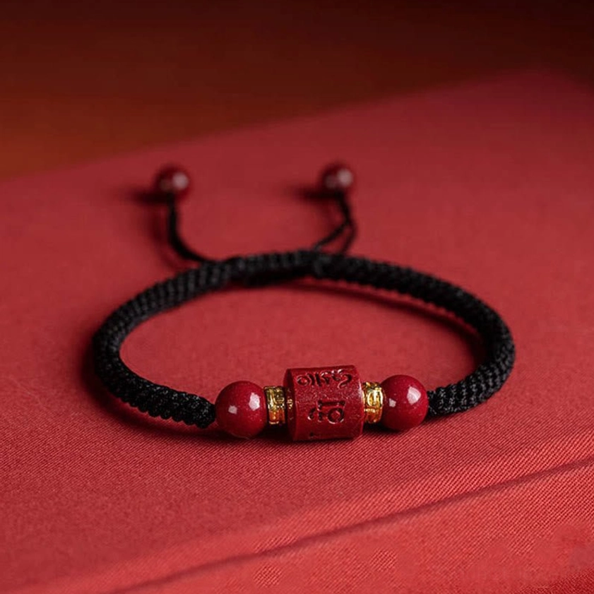 Om Mani Padme Hum Buddhist string bracelet showcasing authentic hand-engraved mantra on natural cinnabar with protective red cord