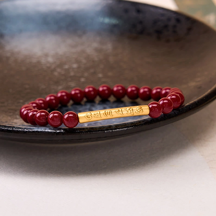Om Mani Padme Hum bracelet laid flat on dark glazed ceramic plate, showing complete view of engraved sacred mantra silver section