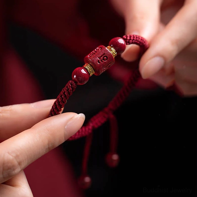 Close-up of adjustable Buddhist red string bracelet showing pull-knot closure mechanism and braided cord texture