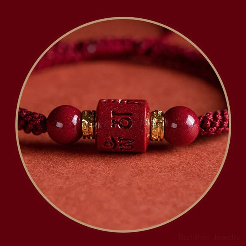 Magnified detailed view of Om Mani Padme Hum cinnabar bracelet highlighting engraved mantra bead, gold spacers, and polished beads