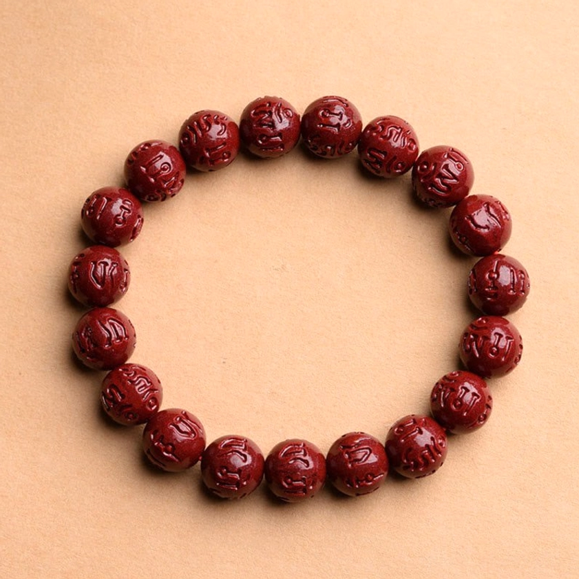 Om Mani Padme Hum cinnabar bracelet with sacred Sanskrit mantra carving on wine-red stone beads, Buddhist prayer beads