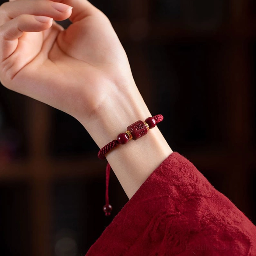 Buddhist mantra bracelet worn on side profile with red rope and cinnabar beads paired with traditional red attire