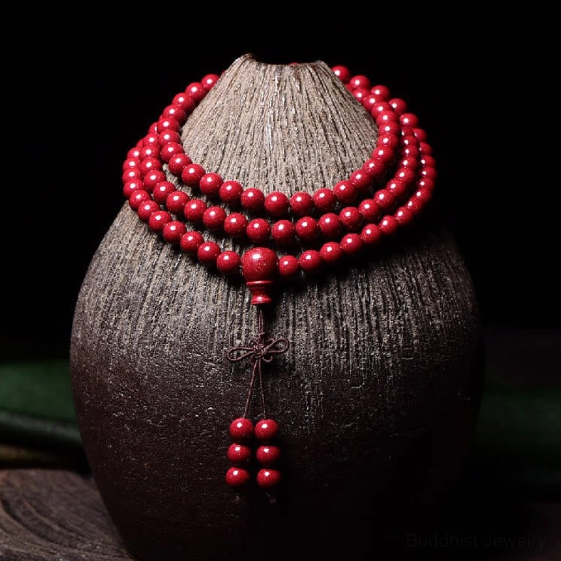 Om Mani Padme Hum cinnabar mala beads showing sacred mantra characters and deep red tone