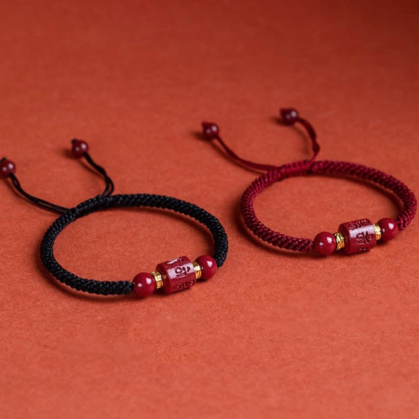 Two styles of Buddhist cinnabar mantra bracelets side by side - red cord and black cord variants with matching charm beads