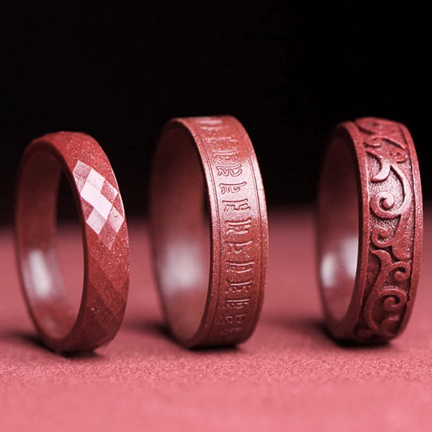 Cinnabar Om Mani Padme Hum Buddhist blessing ring close-up showing sacred mantra carving and natural mineral texture for meditation practice