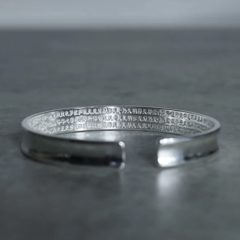 Engraved Buddhist mantra copper bracelet low-angle side-top view showing polished finish and complete inner sutra text