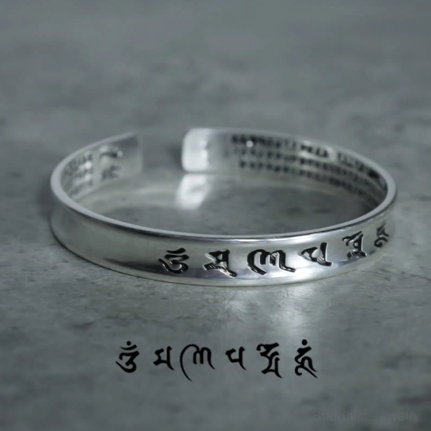 Buddhist mantra copper bangle overhead top-down view showing engraved Tibetan script on inner and outer surfaces