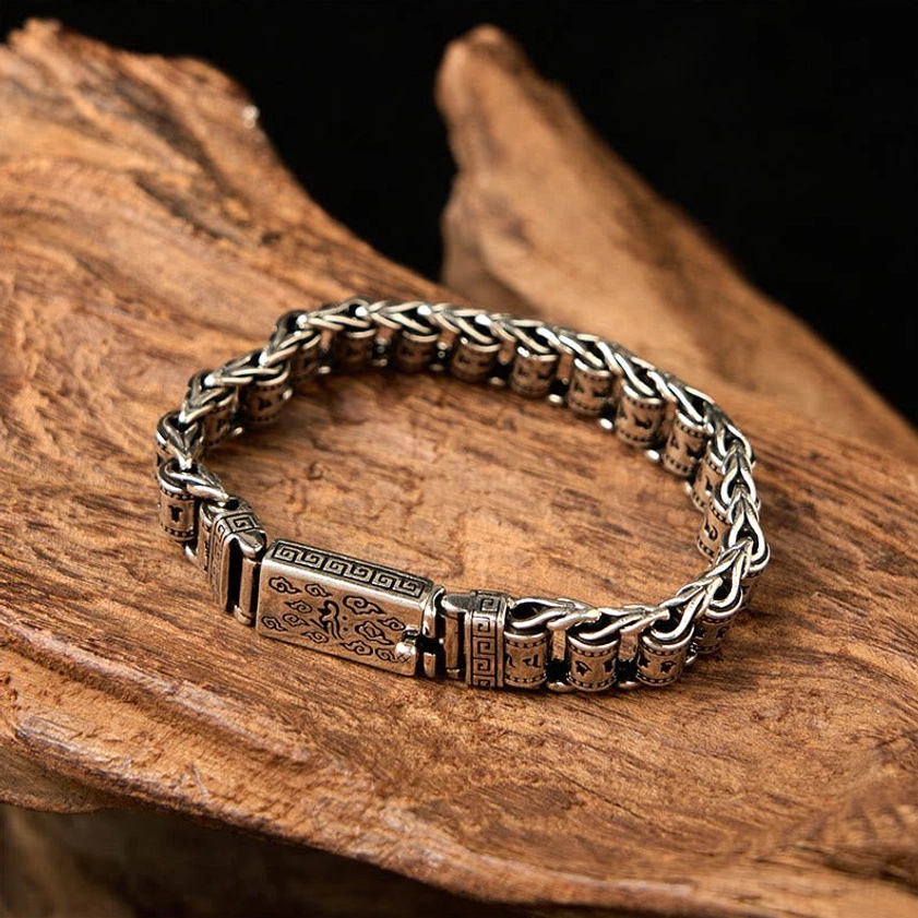 Om Mani Padme Hum copper bracelet flat lay top view showcasing engraved Buddhist mantra design on aged wood