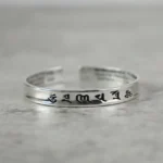 Om Mani Padme Hum copper mantra bracelet with black engraved sacred script, open cuff design front view