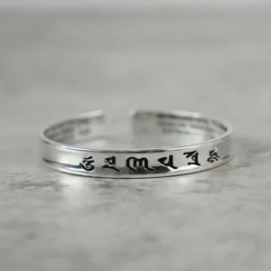 Om Mani Padme Hum copper mantra bracelet with black engraved sacred script, open cuff design front view