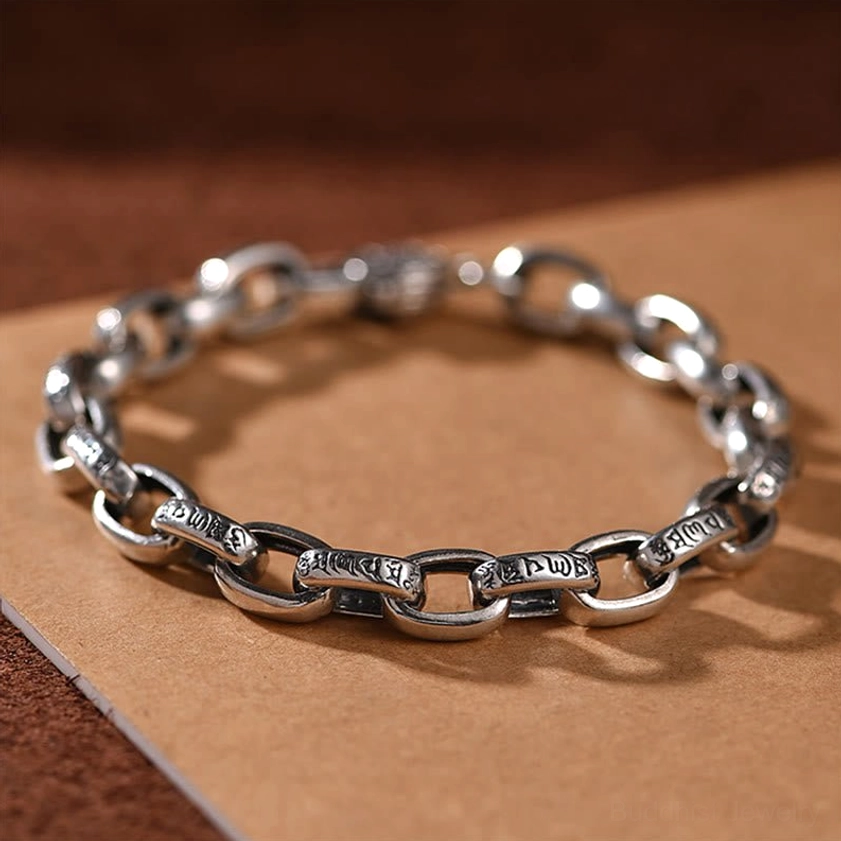 Handcrafted Buddhist copper bracelet with Sacred Six Words engraving, flat lay overhead view showing detailed mantra links