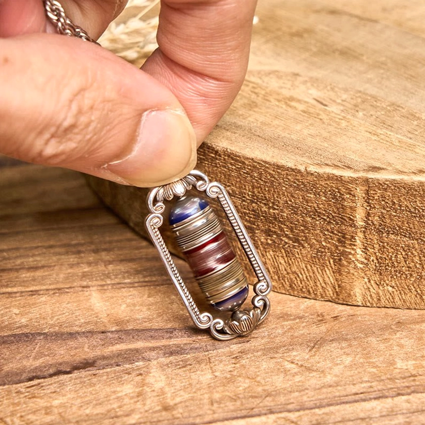 Om Mani Padme Hum copper prayer wheel pendant necklace styling shot with dried floral decoration
