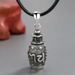 Om Mani Padme Hum copper pendant necklace with black leather rope, frontal close-up view showing engraved Sanskrit mantra