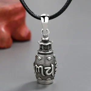 Om Mani Padme Hum copper pendant necklace with black leather rope, frontal close-up view showing engraved Sanskrit mantra