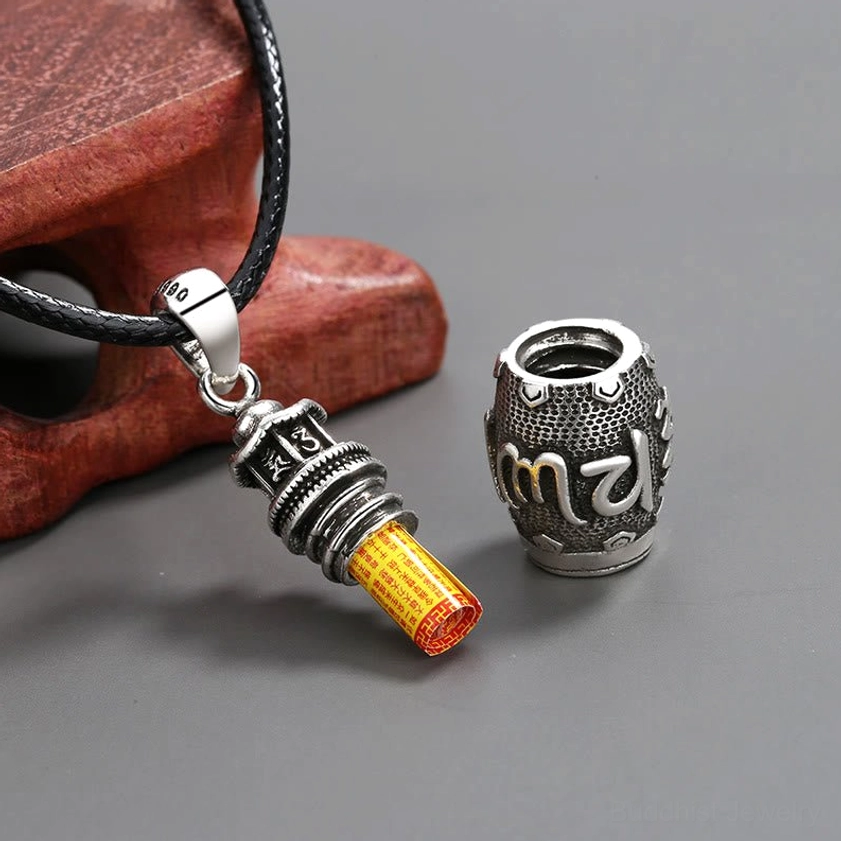 Detachable openable Om Mani Padme Hum copper pendant necklace flat lay, showing hollow cylinder design with inner scroll compartment